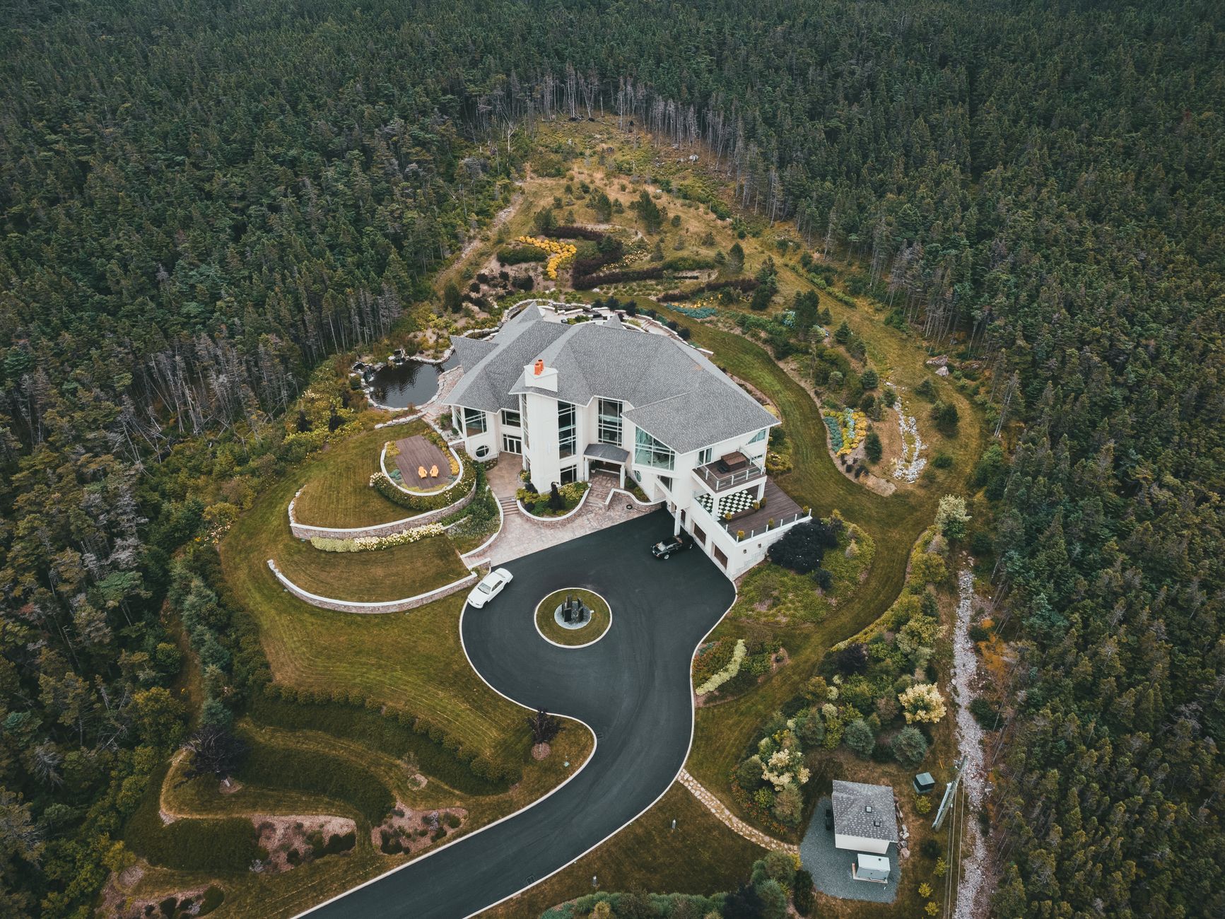 aerial view of white house surrounded with green trees